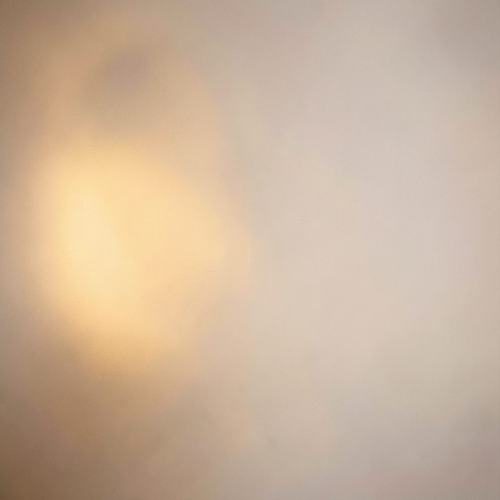 Warm metallic glow against a soft neutral backdrop